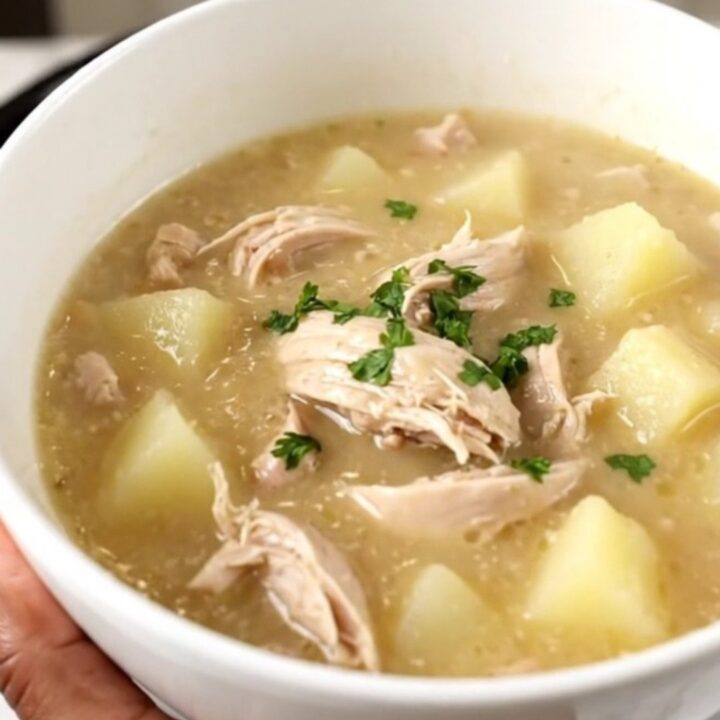 A steaming bowl of creamy chicken chowder filled with diced chicken and potatoes.