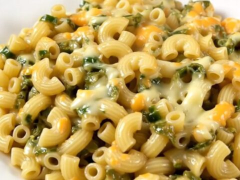 A top-down view of creamy macaroni with green chiles and melted Monterey Jack cheese in a slow cooker.