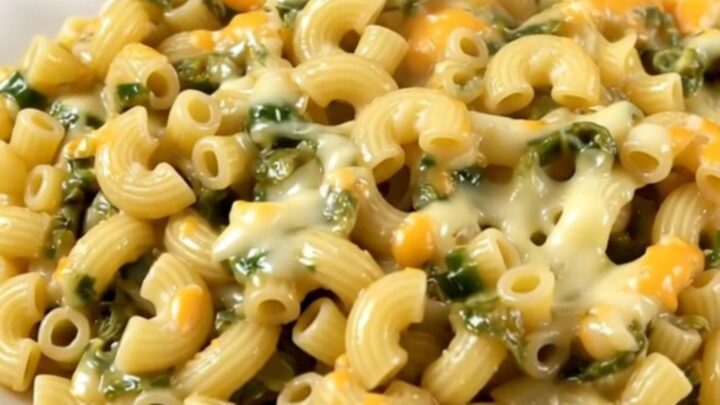 A top-down view of creamy macaroni with green chiles and melted Monterey Jack cheese in a slow cooker.