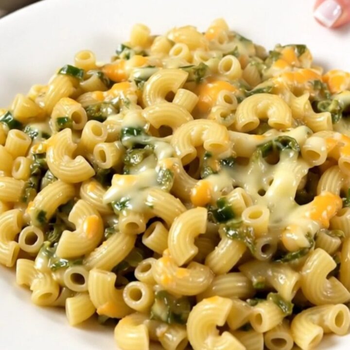A top-down view of creamy macaroni with green chiles and melted Monterey Jack cheese in a slow cooker.