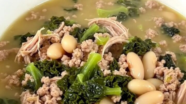 A steaming bowl of slow cooker ground turkey and white bean soup with kale, served in a white bowl.