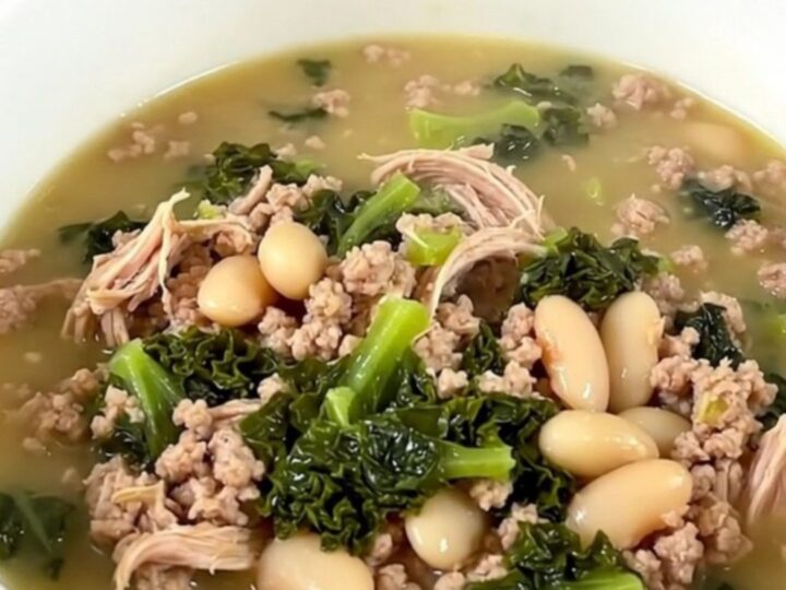 A steaming bowl of slow cooker ground turkey and white bean soup with kale, served in a white bowl.