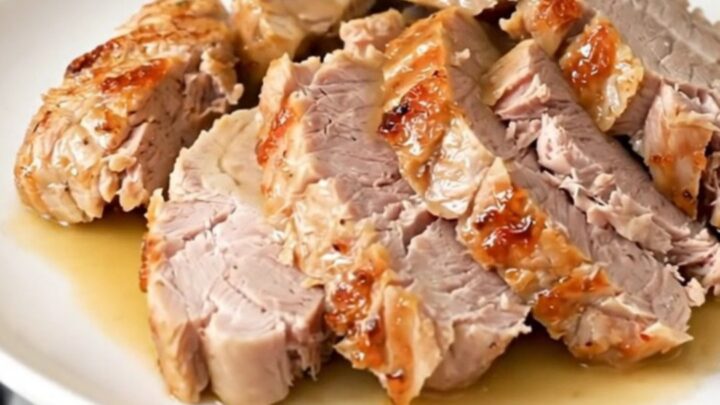 A plate of sliced, tender pork tenderloin drizzled with savory pan juices and sun-dried tomatoes.