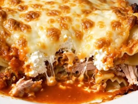 A steaming, glossy ground turkey lasagna casserole served on a white plate.