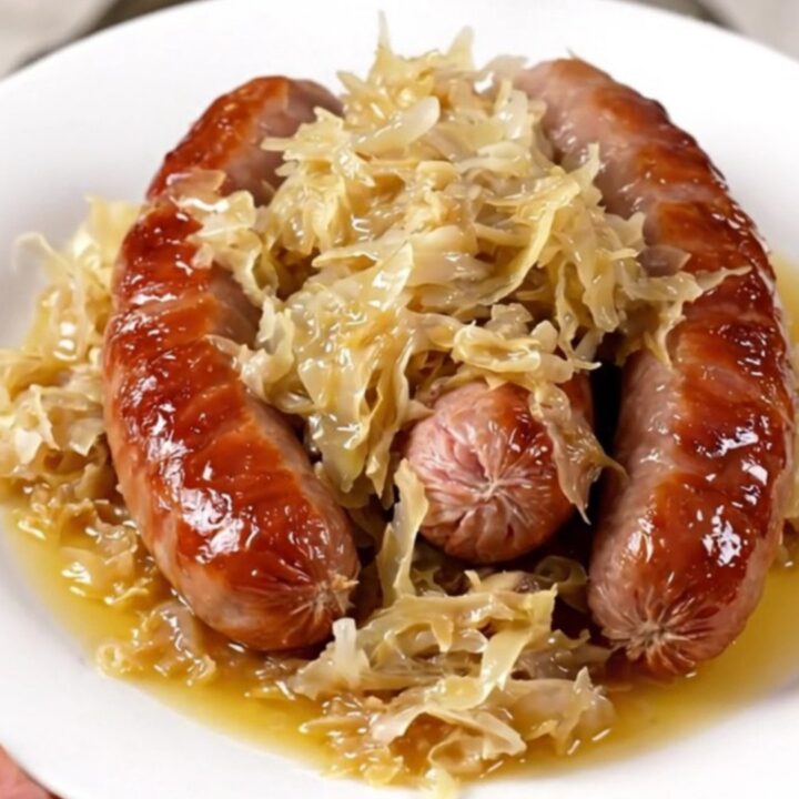 A rustic bowl of choucroute garnie featuring tender smoked pork, sauerkraut, and steamed potatoes.