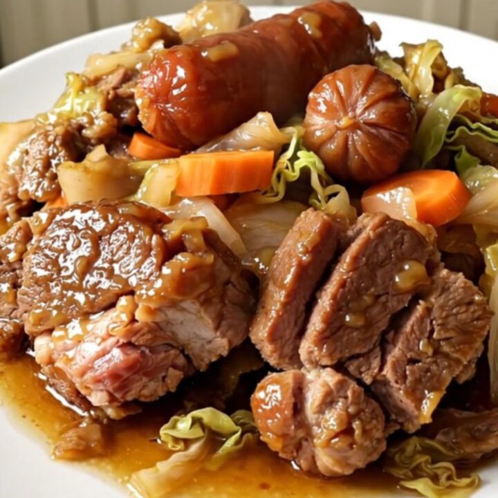 A rustic slow cooker Potée Auvergnate served in a white bowl with tender pork, carrots, and cabbage.