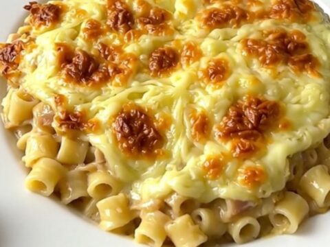A rustic slow cooker filled with creamy croziflette, showing melted Reblochon cheese and bits of bacon.