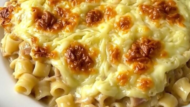 A rustic slow cooker filled with creamy croziflette, showing melted Reblochon cheese and bits of bacon.