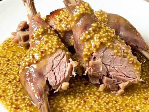 Slow Cooker Dijon Rabbit with White Wine served in a white bowl with a rich mustard sauce.