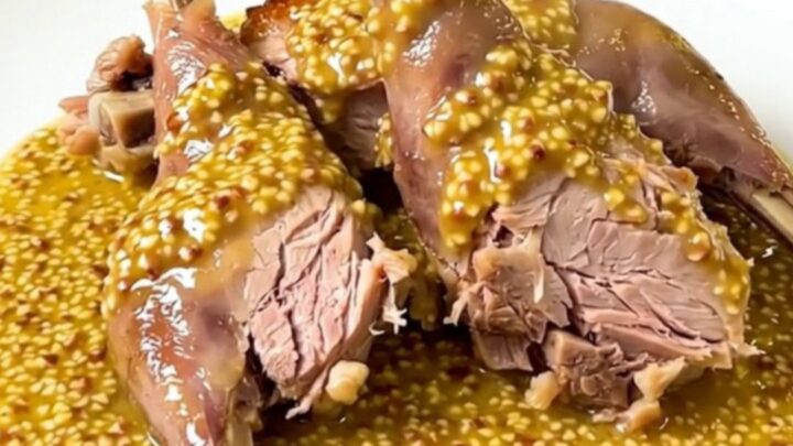 Slow Cooker Dijon Rabbit with White Wine served in a white bowl with a rich mustard sauce.