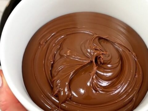 A close-up of a bowl filled with homemade chocolate hazelnut spread, showcasing its smooth and glossy texture.