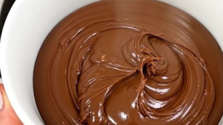 A close-up of a bowl filled with homemade chocolate hazelnut spread, showcasing its smooth and glossy texture.