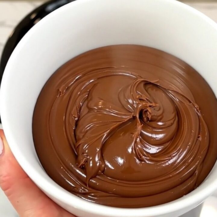A close-up of a bowl filled with homemade chocolate hazelnut spread, showcasing its smooth and glossy texture.
