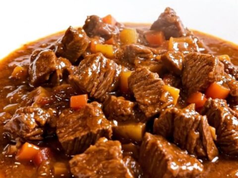 A rustic Provençal beef daube served in a white bowl with a rich red wine sauce.