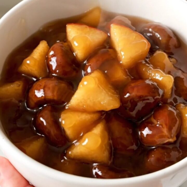 Compote de pommes et châtaignes dans un bol blanc, vue rapprochée avec vapeur.