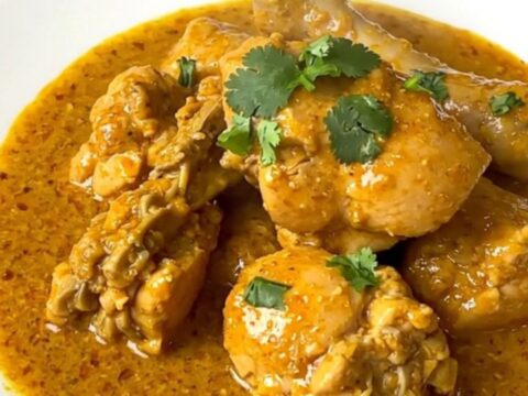 Slow cooker coconut curry chicken served on a white plate with a creamy sauce.