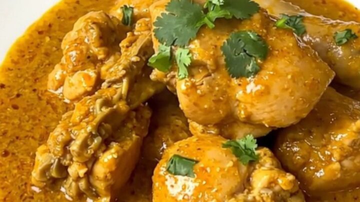 Slow cooker coconut curry chicken served on a white plate with a creamy sauce.