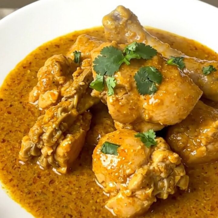 Slow cooker coconut curry chicken served on a white plate with a creamy sauce.