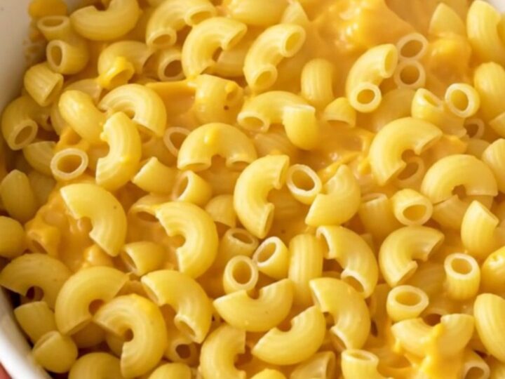A top-down view of raw macaroni and ingredients in a slow cooker before cooking.
