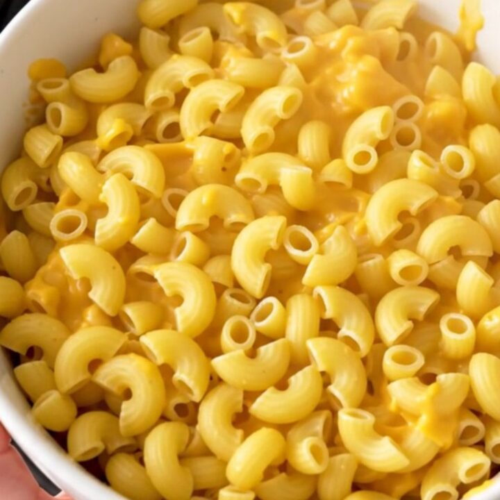 A top-down view of raw macaroni and ingredients in a slow cooker before cooking.
