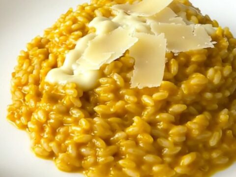 A steaming, creamy pumpkin and parmesan risotto served on a white plate.