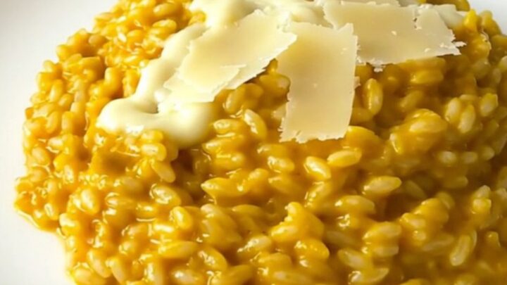 A steaming, creamy pumpkin and parmesan risotto served on a white plate.