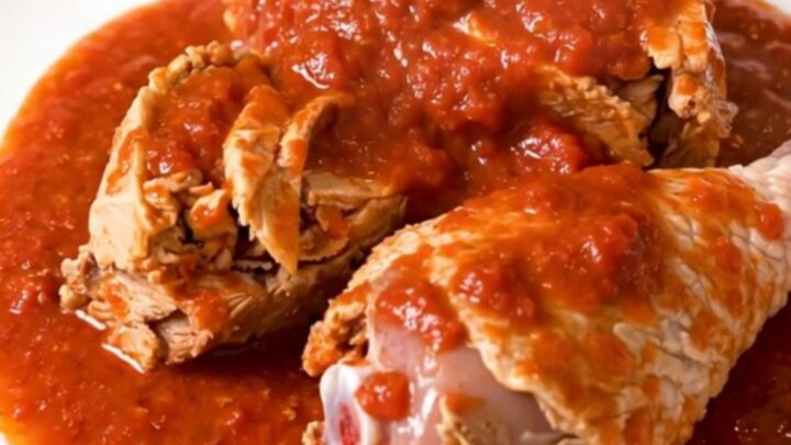 Close-up of slow cooker turkey osso buco served on a white plate with glossy tomato sauce.