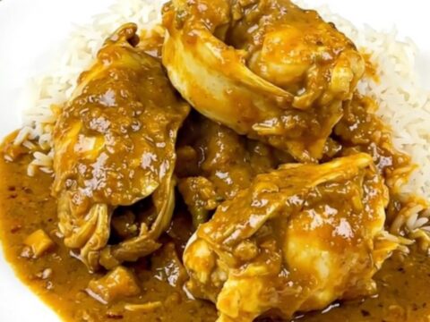 Slow cooker coconut curry monkfish served on a white plate with steamed rice.