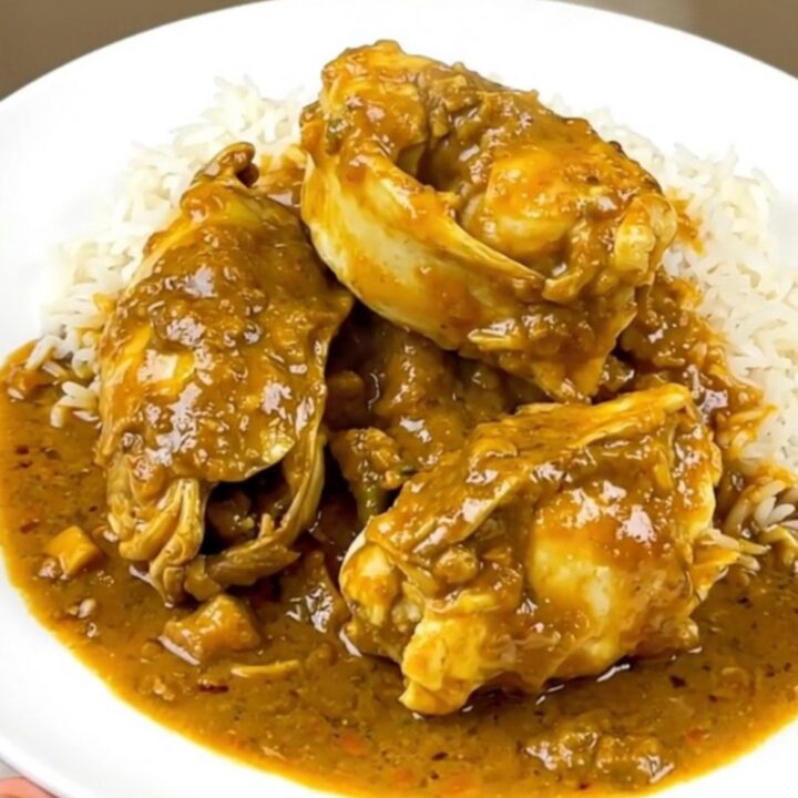 Slow cooker coconut curry monkfish served on a white plate with steamed rice.
