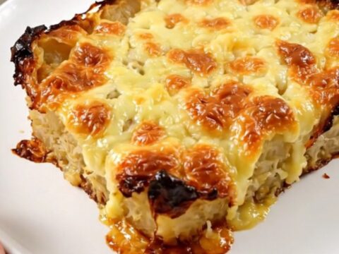 A warm, golden-brown slow cooker red kuri squash and Comté gratin in a white bowl.