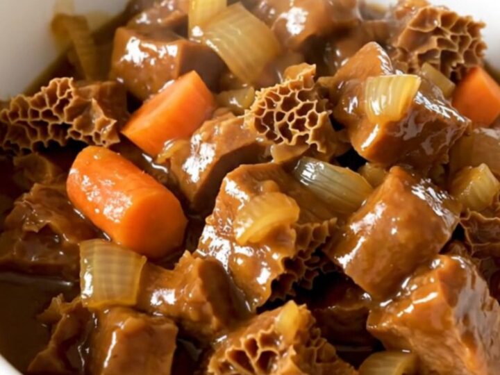 Bol de tripes à la mode de Caen fumantes avec une sauce brillante.