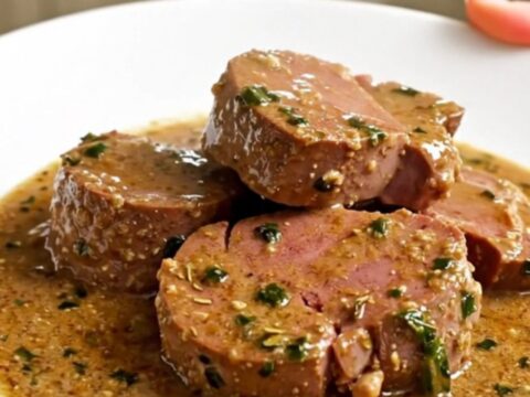 Mijoté de veau crémeux à l'estragon servi dans une assiette blanche avec une sauce onctueuse.