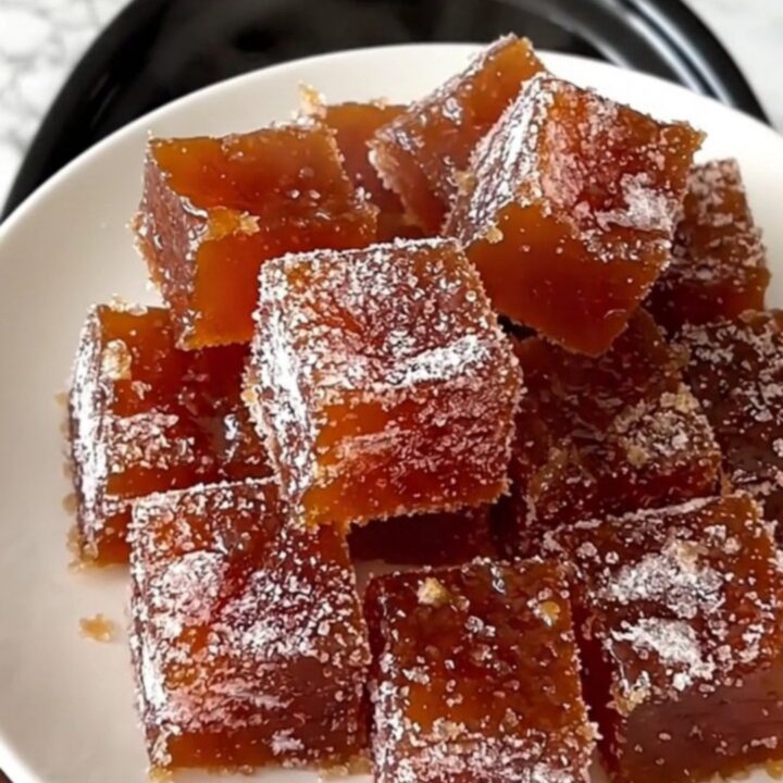 A rustic platter featuring squares of ruby-amber quince paste arranged next to slices of aged Manchego cheese.