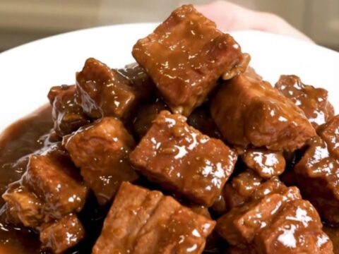 A close-up of a finished Slow Cooker Pork Carbonnade served in a bowl, featuring tender pork cubes and a rich