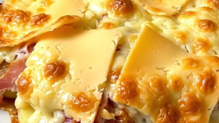 A top-down view of a black slow cooker filled with layers of potatoes, bacon, and thick slices of Maroilles cheese.