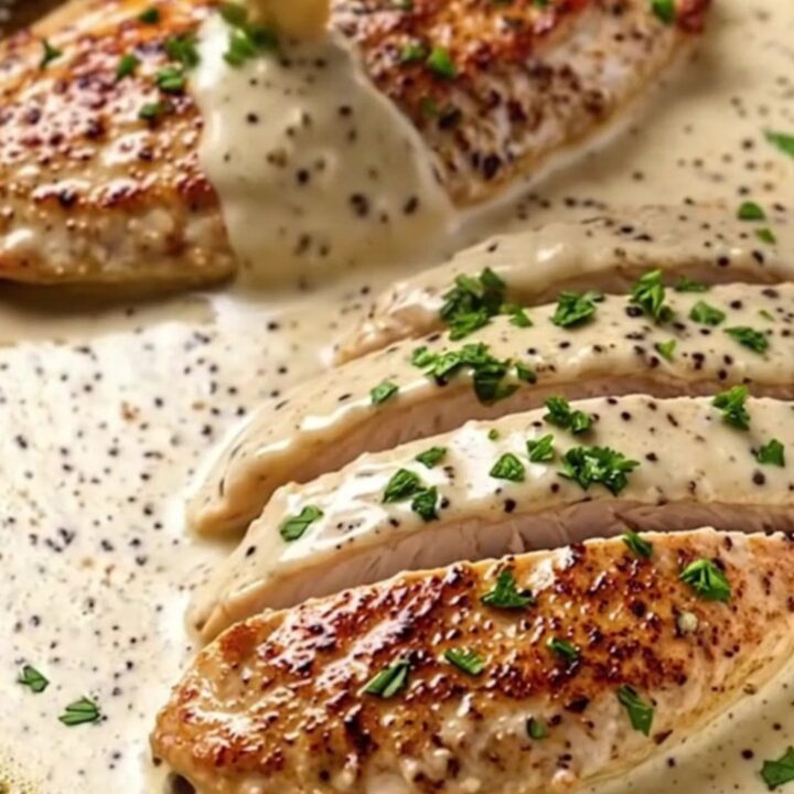 Creamy garlic butter chicken breast served in a skillet with a rich, velvety sauce and fresh parsley garnish.