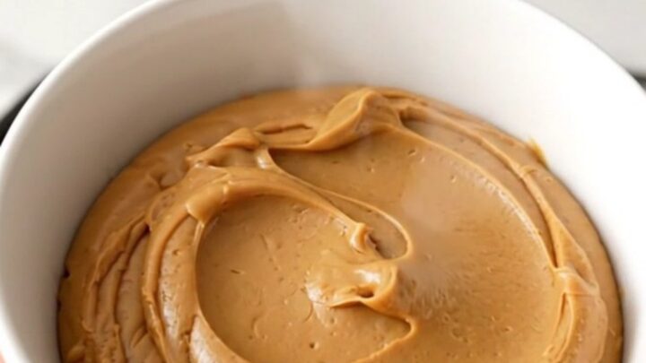 A ceramic bowl filled with glossy, smooth speculoos cookie butter spread.