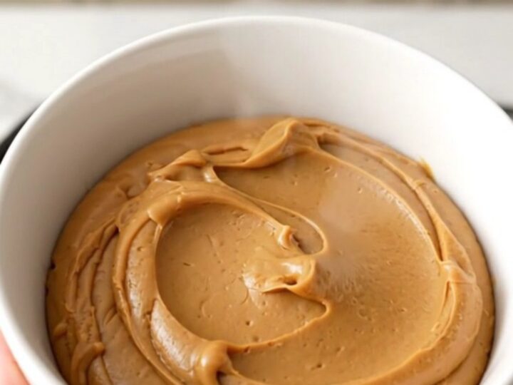 A ceramic bowl filled with glossy, smooth speculoos cookie butter spread.
