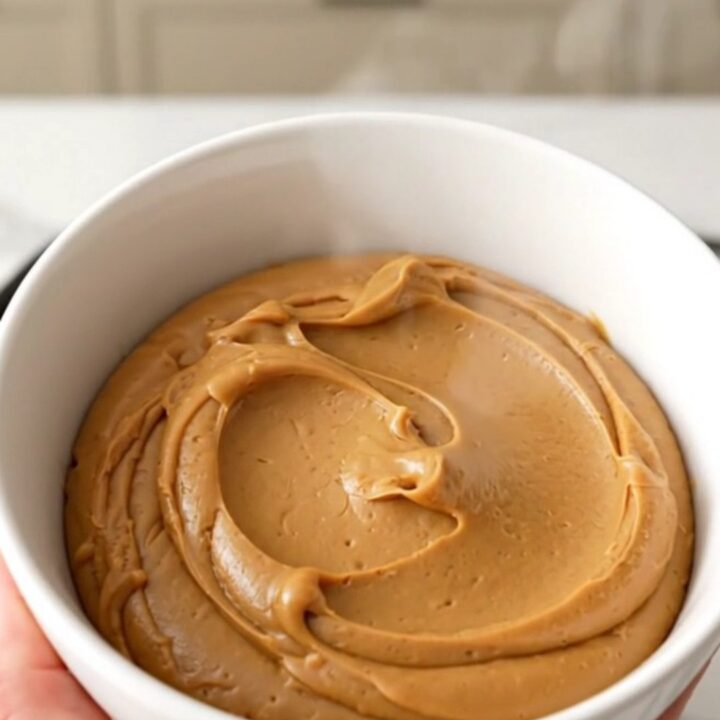 A ceramic bowl filled with glossy, smooth speculoos cookie butter spread.