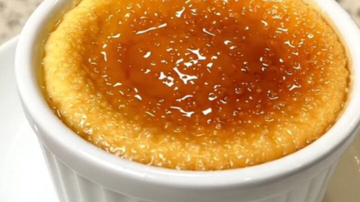 A top-down view of four ramekins of creamy vanilla crème brûlée arranged in a slow cooker.