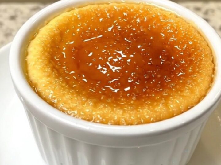 A top-down view of four ramekins of creamy vanilla crème brûlée arranged in a slow cooker.