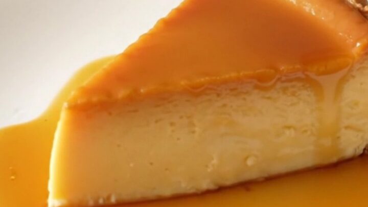 A thick, glossy slice of golden crustless custard tart on a white plate.