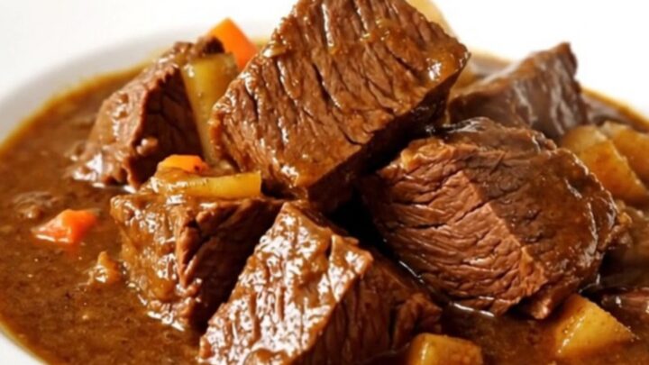 Bœuf bourguignon mijoté dans une mijoteuse noire sur un plan de travail en quartz blanc.