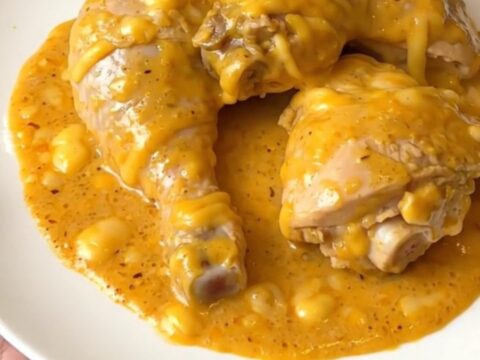 Slow cooker Maroilles chicken with creamy sauce in a black oval slow cooker on a quartz countertop.