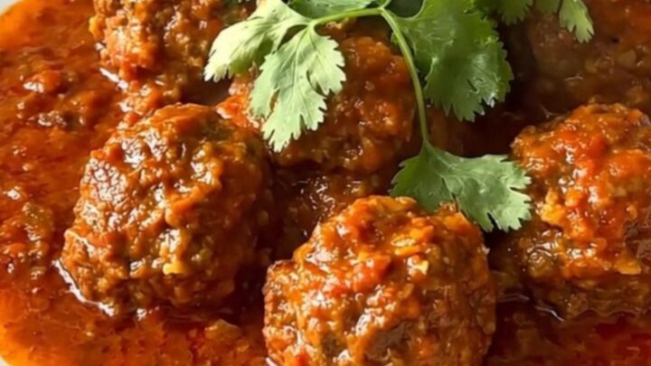 A steaming, flavorful beef kefta tagine served in a white bowl with a rich tomato sauce.