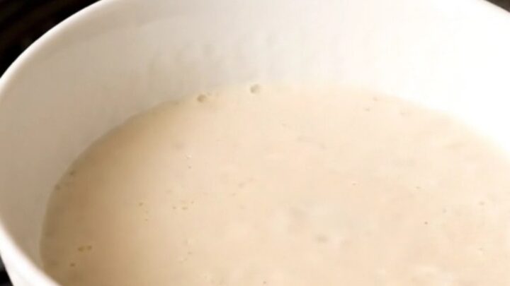 A warm bowl of creamy homemade eggnog garnished with a light dusting of freshly grated nutmeg.