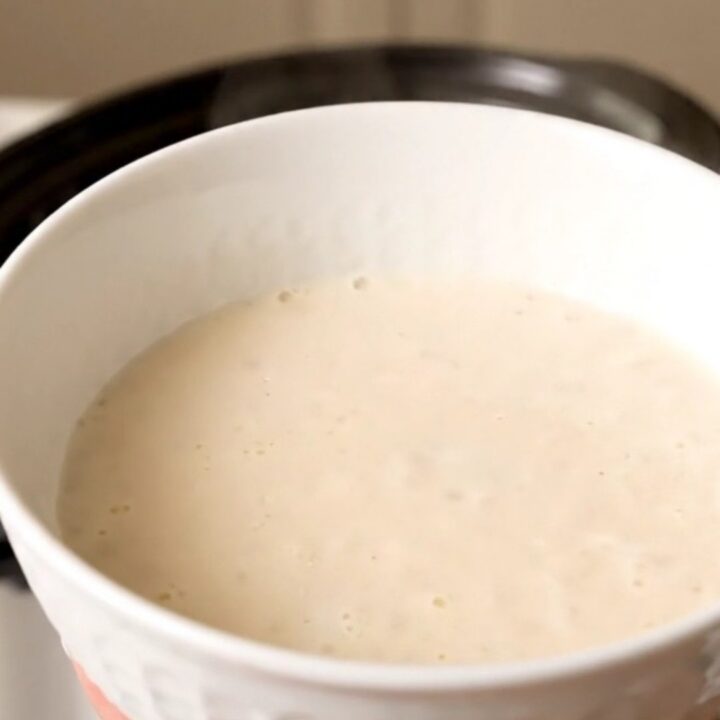 A warm bowl of creamy homemade eggnog garnished with a light dusting of freshly grated nutmeg.