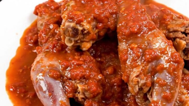 A rustic slow cooker filled with Provencal rabbit in a rich tomato sauce with rosemary sprigs and olives.