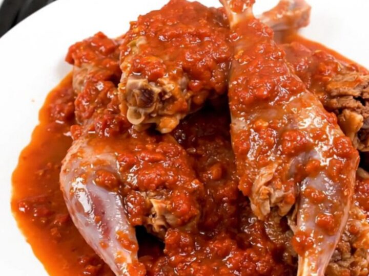 A rustic slow cooker filled with Provencal rabbit in a rich tomato sauce with rosemary sprigs and olives.