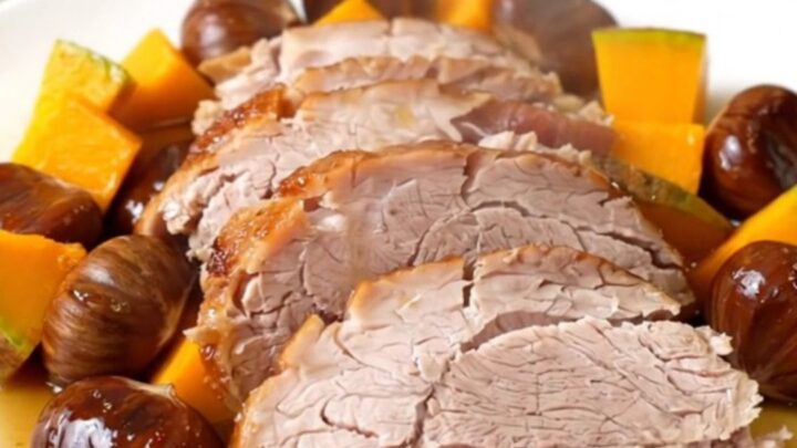 A slow cooker filled with a pork roast, chunks of red kuri squash, and whole chestnuts.